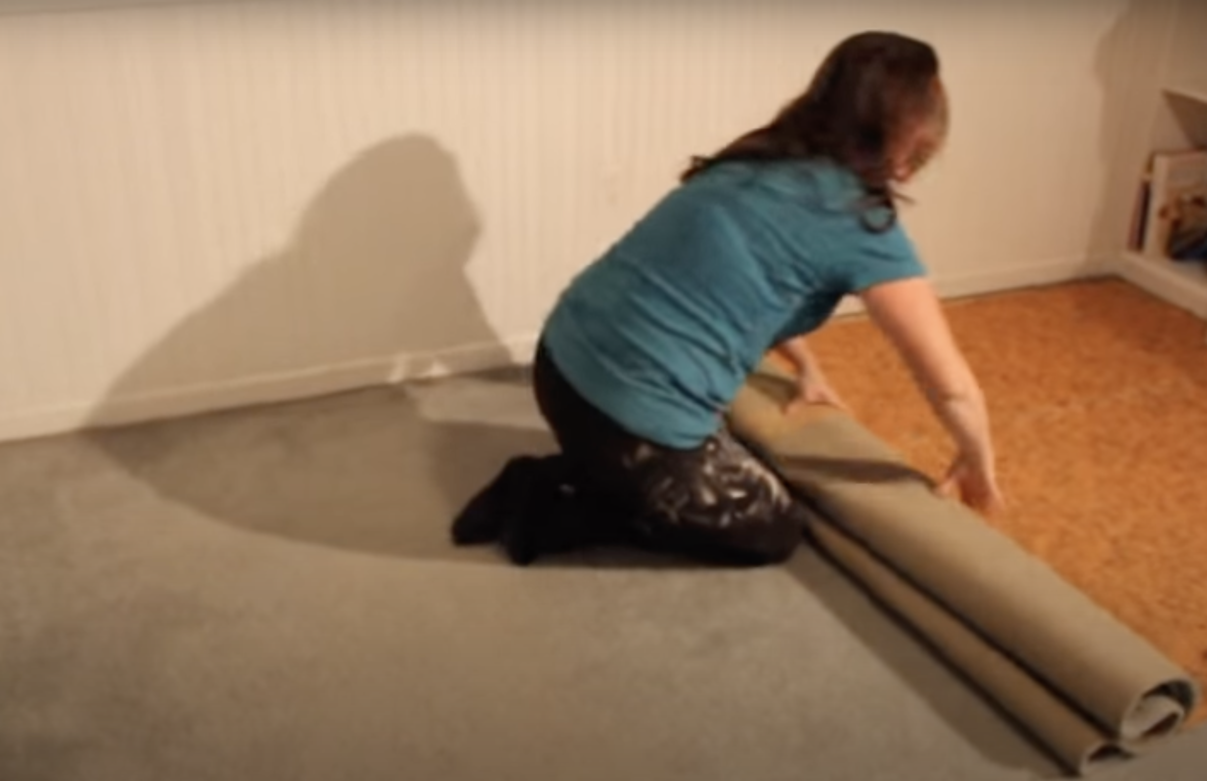 Beth Allen rolls up a carpet pad